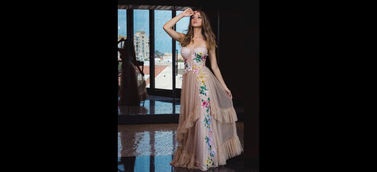 THALÍA SEGRERA: Vestido strapless estilo corsé corte en A y sobre falda en tul elaborado en malla metalizada color oro rosa con apliques bordados en flores de colores.